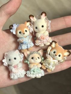 small stuffed animals are sitting on someone's hand in wedding attires and dresses