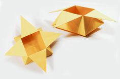 two golden origami pieces on a white surface