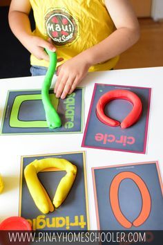 a little boy that is standing in front of a table with some letters on it