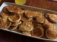 a white plate topped with pancakes next to a glass of orange juice