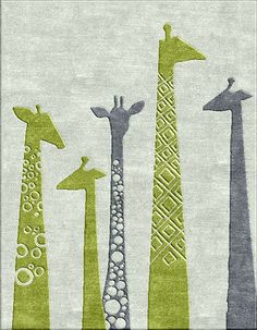 three giraffes are standing in the middle of an area rug that has circles and squares on it