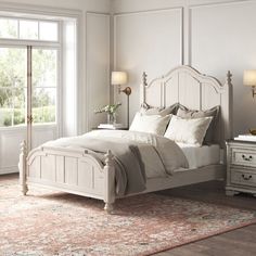 a white bed sitting in a bedroom on top of a rug