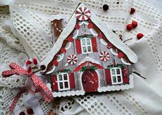 a gingerbread house ornament with candy canes