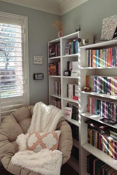 a chair in front of a book shelf filled with books