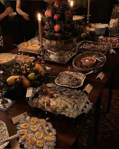 a table filled with lots of food next to a christmas tree