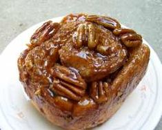 a close up of a muffin on a plate with pecans in the middle