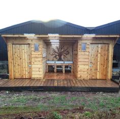 a small wooden structure with benches on the outside and in between it is a fenced in area