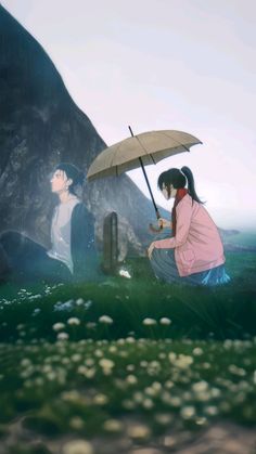 two people sitting in the grass with an umbrella