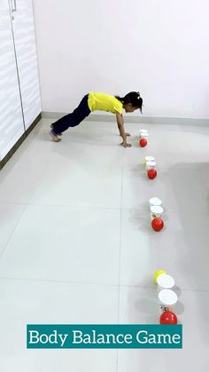 a young boy is playing with cups on the floor