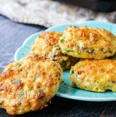 four crab cakes on a blue plate with broccoli in the background and a crock pot to the side