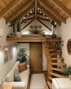 a living room filled with furniture next to a staircase leading up to a loft bed