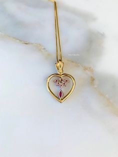 Metal: 14kt Yellow And White Gold Stone: Ruby And Diamond Shape: Marquise- Shape And Round Approximate Ruby Weight: .66 ctw Approximate Diamond Weight: .10 ctw Weight of entire piece with chain: 6.60 grams Type of Chain: .80mm Box Chain Type of Clasp: Spring Clasp Pendant Dimensions: 32.24mm long including bail, and 20.65mm wide. Length of 14kt yellow gold chain: Please select. If you don't see your desired length please state in note box at checkout. Thank you. Gold Heart Necklace With Gemstone For Anniversary, Fine Jewelry Heart Necklace With Gemstone For Anniversary, Fine Jewelry Gemstone Heart Necklace For Anniversary, Anniversary Yellow Gold Heart Necklace With Gemstone, Heart Shaped Diamond Necklace With 17 Jewels For Wedding, Gold Gemstone Heart Necklace For Wedding, Valentine's Day Formal Diamond Necklace With 17 Jewels, Yellow Gold Gemstone Heart Necklace For Anniversary, Yellow Gold Heart Necklace For Formal Occasions