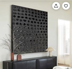 a living room with a large black piece of art on the wall