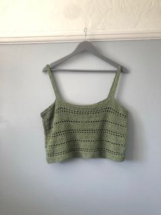 a green crop top hanging on a wall