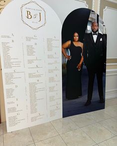 a man and woman in formal wear standing next to a wall with information on it