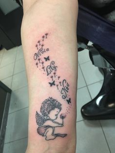 a small tattoo on the arm of a girl with an angel and stars above her head