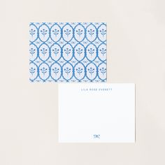 two blue and white envelopes sitting next to each other on top of a table