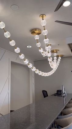 a long table with chairs and lights hanging from it's ceiling in an office