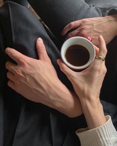 two hands holding a cup of coffee