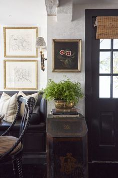 a living room filled with furniture and pictures on the wall next to a black door