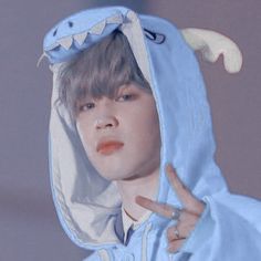 a young man wearing a blue hoodie with a shark on it's face