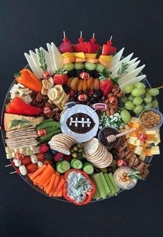 a football themed platter with cheeses, crackers and fruit