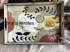 there is a box that has flowers on it and the words marta mirales written in black