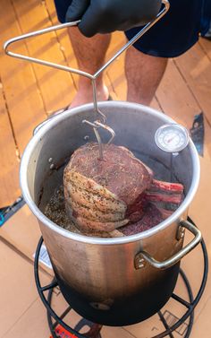 a large pot that has some meat in it on top of a stove burner