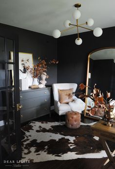 a living room filled with furniture and a large mirror on top of a dresser next to a chair