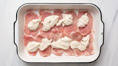 raw meat in a baking dish with cream cheese on top