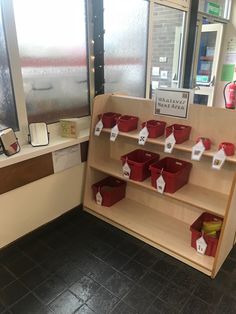 there are many red buckets on the shelf in this store's front window