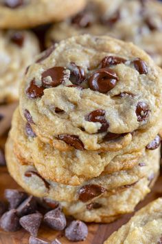 chocolate chip cookies stacked on top of each other with one cookie in the middle and more scattered around