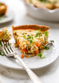 a slice of quiche on a white plate with a fork next to the pie