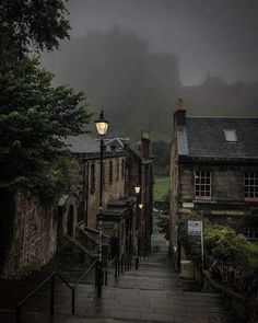 an alley way in the rain with buildings on both sides and foggy skies overhead