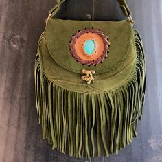 Handmade Original. Only One Left. Sage Green Suede Fringed Bag/ Crossbody/ Shoulder Bag. Vegetable Dyed. Beautiful Braided Detail With Turquoise Color Accent. Measures 6.5 Inches Long And 9 Inches Across. Adjustable Strap. Perfect For Everyday Use Or Just In Time To Compliment Your Festival Look Green Bohemian Bags With Leather Handles, Bohemian Green Bag With Fringe, Bohemian Green Leather Bags, Green Fringe Shoulder Bag For Everyday Use, Green Fringe Travel Bag, Green Travel Bag With Fringe, Green Crossbody Shoulder Bag For Festivals, Green Bohemian Crossbody Satchel, Green Crossbody Bag For Festival