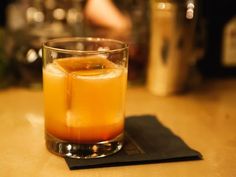 a glass filled with liquid sitting on top of a table