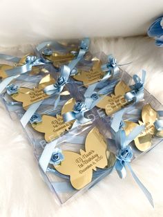 six blue and gold butterfly shaped tags with ribbons on white furnishing next to stuffed animal