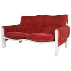 a red and white couch sitting on top of a wooden table