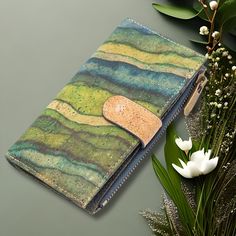 a wallet is sitting next to some flowers