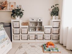 a living room filled with lots of white boxes and containers on top of each other