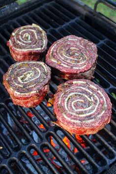 three hamburger patties are cooking on the grill