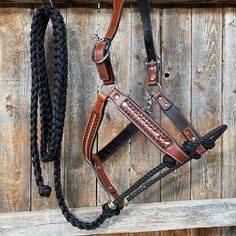 a bridle and reins hanging on a wooden fence