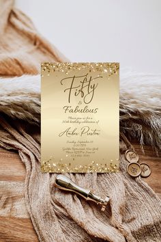 a gold foiled 50th birthday party card on top of a furnishing rug