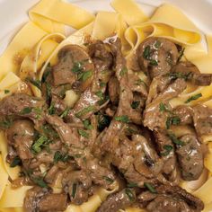 a white plate topped with pasta covered in meat and sauce