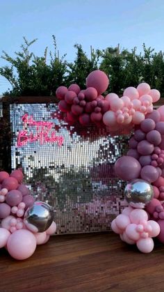 pink balloons are floating in front of a mirror