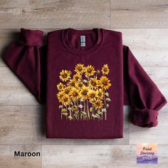 Embrace the warmth and charm of autumn with this cozy sunflower sweatshirt. Featuring a vibrant yellow flower design, this comfortable casual wear piece is perfect for the fall season. The unique botanical print adds a touch of nature to your wardrobe, making it a standout choice for any casual occasion. Stay stylish and warm with this delightful fall fashion top!  Gildan 18000 Sweatshirt: A sturdy and warm sweatshirt bound to keep you warm in the colder months. A pre-shrunk, classic fit sweater Cotton Floral Print Fall Sweater, Cotton Floral Print Sweater For Fall, Fall Cotton Floral Print Sweater, Fall Cotton Sweater With Floral Print, Yellow Crew Neck Sweatshirt For Fall, Spring Long Sleeve Sunflower Print Top, Long Sleeve Sunflower Print Tops For Spring, Floral Print Long Sleeve Sweatshirt For Fall, Spring Long Sleeve Top With Sunflower Print