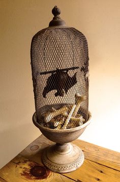 a birdcage filled with assorted items on top of a wooden table