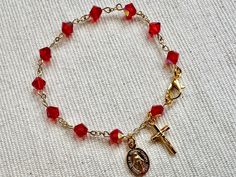 This gorgeous bracelet along a gold plated chain features 6mm red crystal stone beads. The traditional miraculous medal and crucifix, both made in Italy, add to the final touches of this beautiful bracelet. Cheap Red Rosary Bracelet As Gift, Cheap Red Rosary Bracelet Gift, Cheap Red Rosary Bracelet For Gift, Catholic Rosary Bracelet, Catholic Bracelet, Rosary Bracelet, Rosary Catholic, Miraculous Medal, Red Crystals