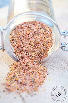 a jar filled with lots of different colored sprinkles on top of a wooden table