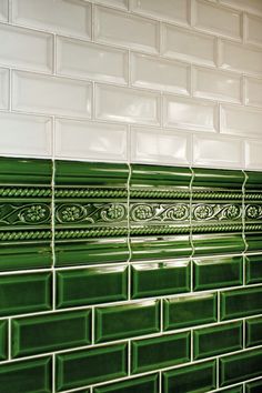 a green and white tiled wall in a bathroom